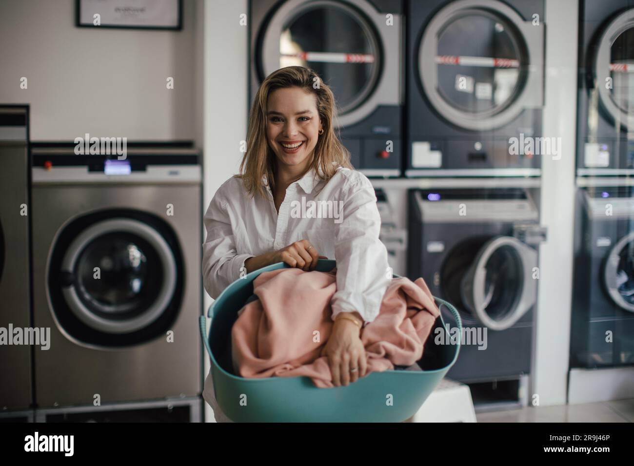 Young woman posing in a laundry room. Stock Photo