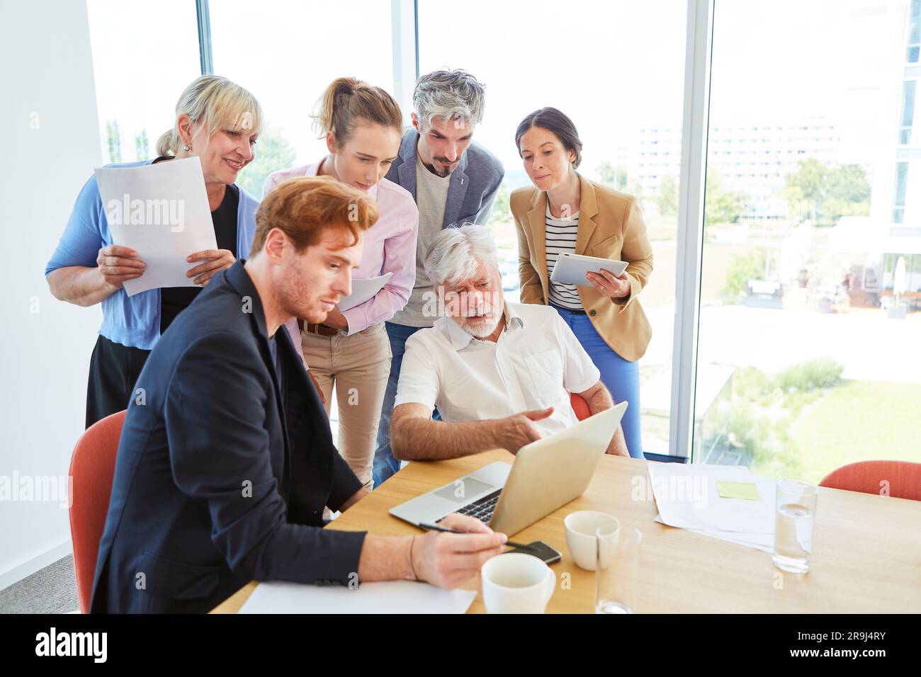 Colleagues discussing over laptop while planning strategy at office Stock Photo