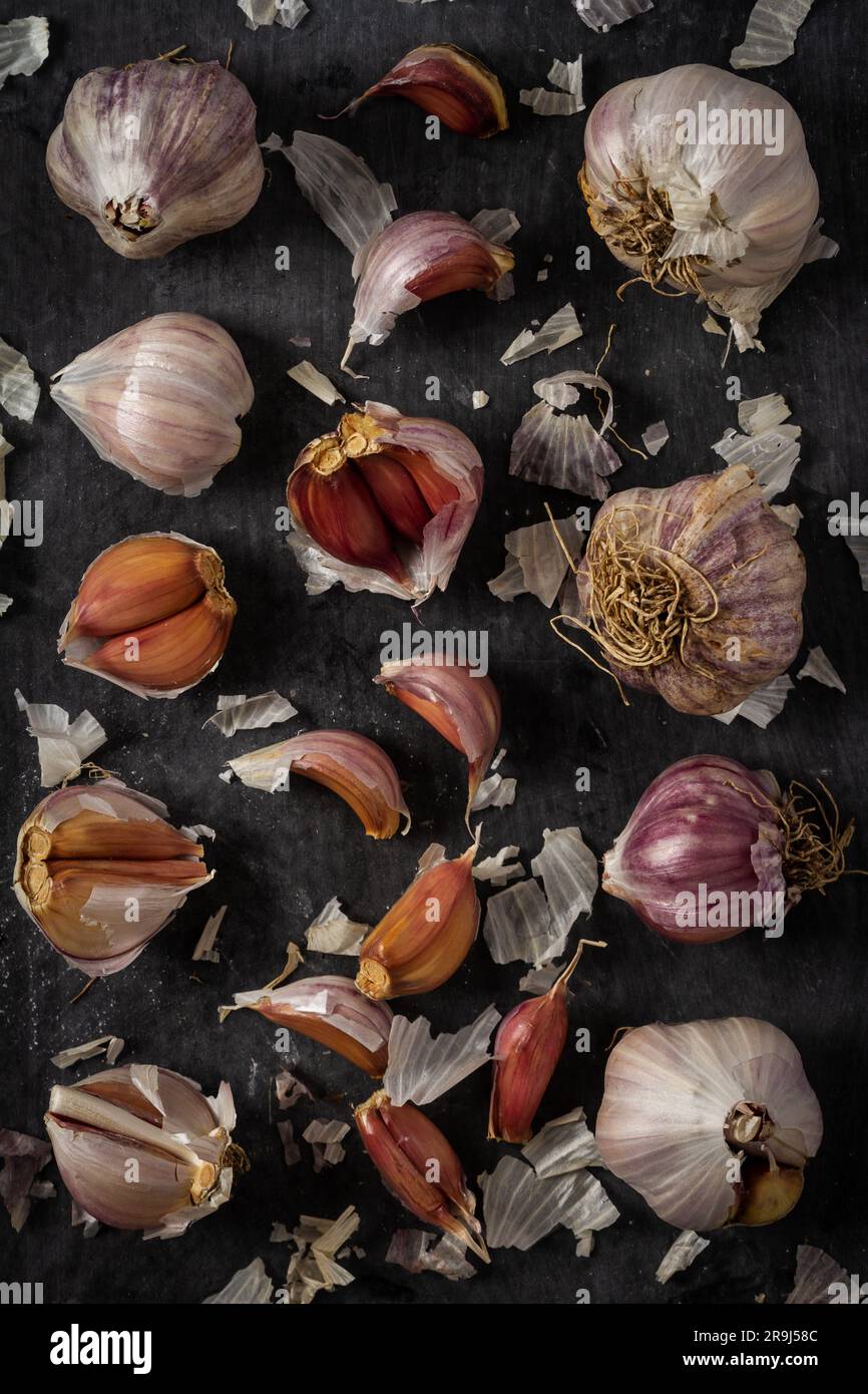 Fresh garlic bulbs and cloves grouped on black background. Flat lay ...
