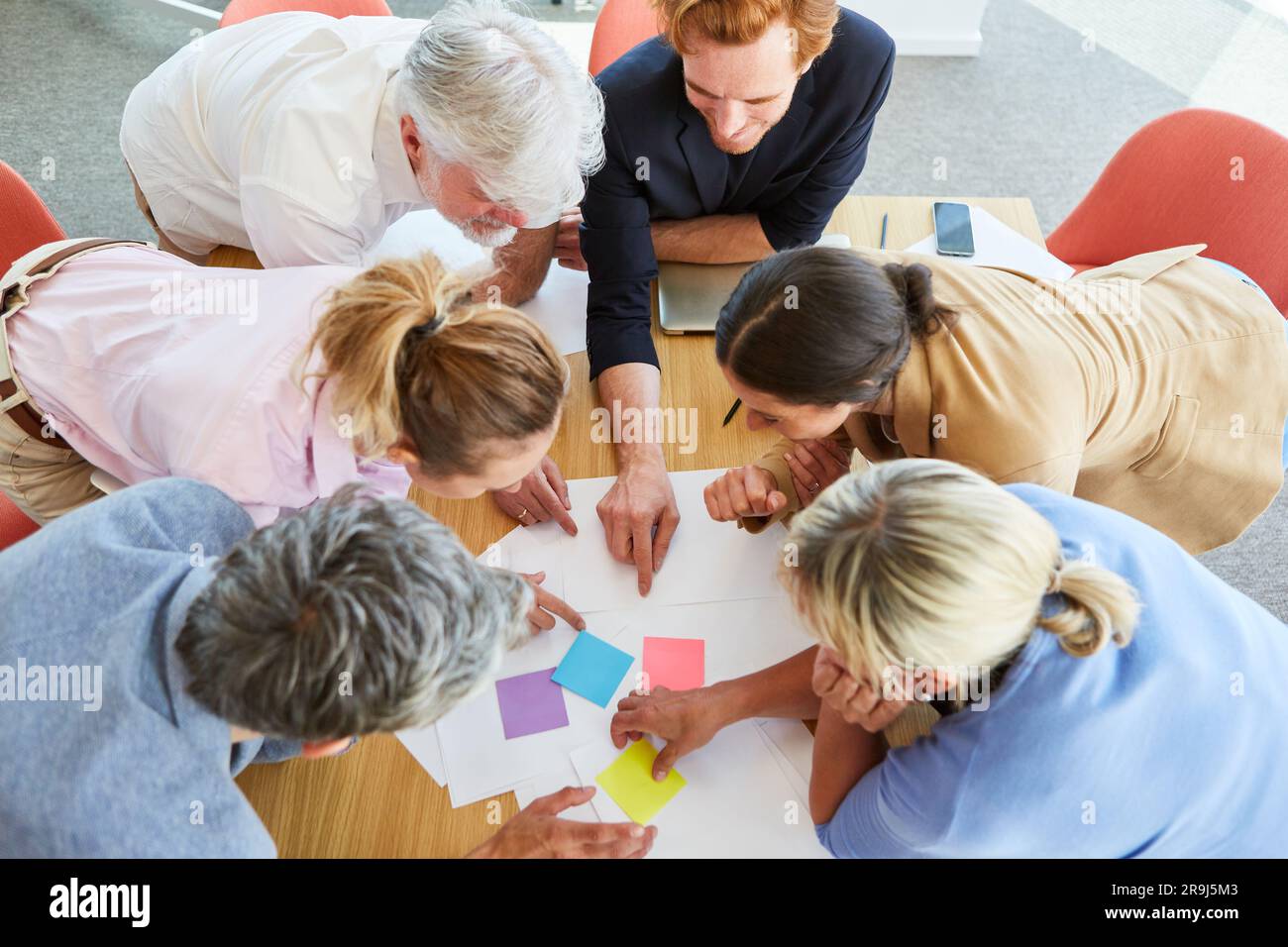 Business professionals discussing over documents and sticky notes Stock Photo