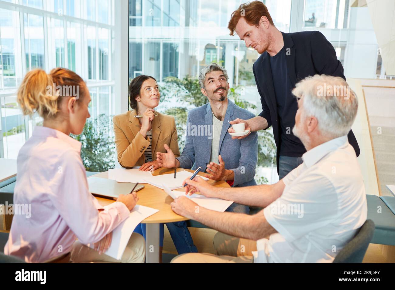 Confident businessman discussing with male and female colleagues Stock Photo