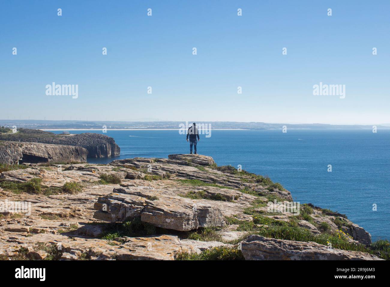 man looking at the blue sea on the edge of the cliff Cabo Carvoeiro Peniche Portugal peniche; portugal Stock Photo