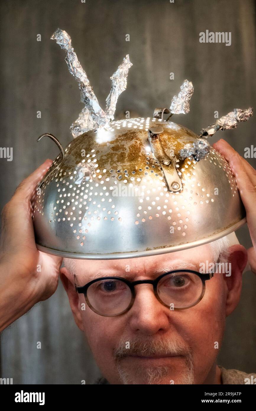 Man wearing tinfoil hat due to the superstition of extraterrestrial activity and paranormal occurrences, 2023, United States Stock Photo