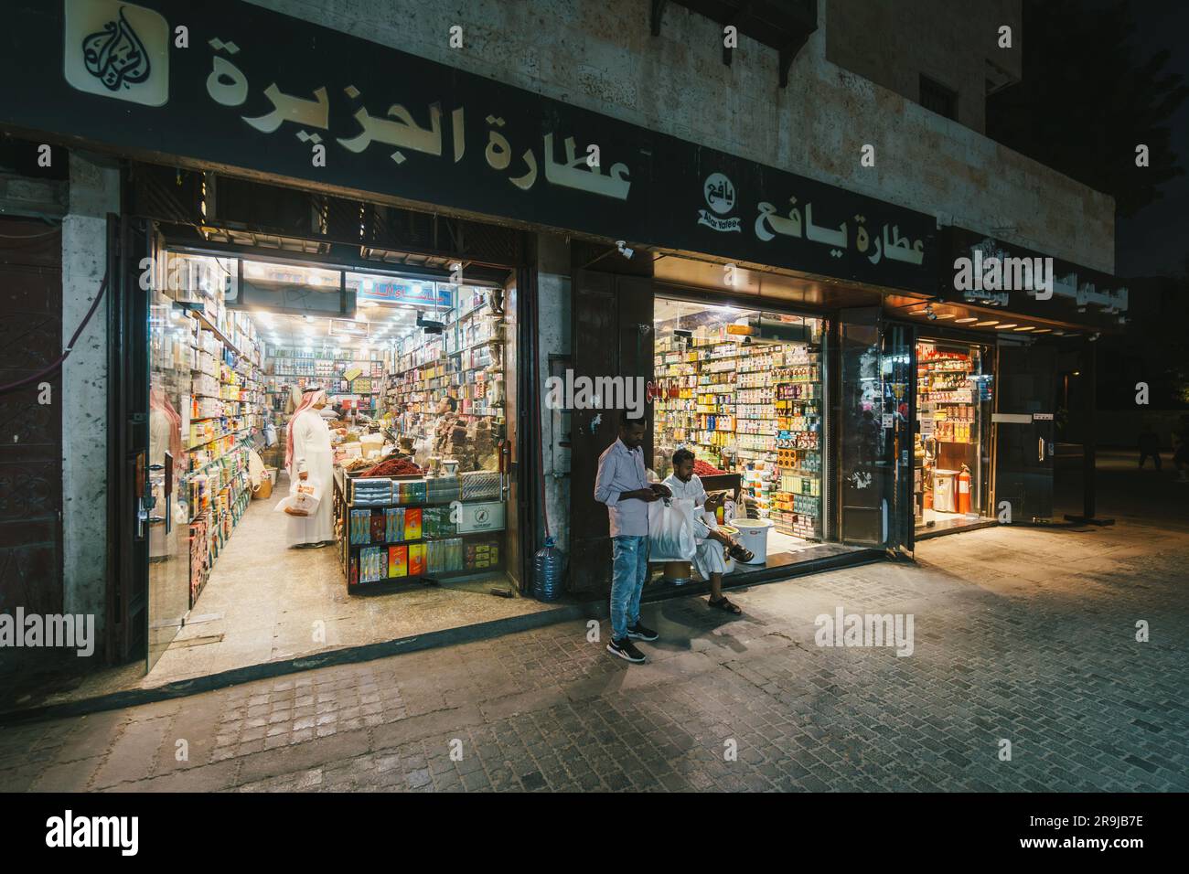 Jeddah, Saudi Arabia - January 26 2023: Two shopkeepers wait for customer in Jeddah old town Al-Balad Souq in Saudi Arabia at night Stock Photo