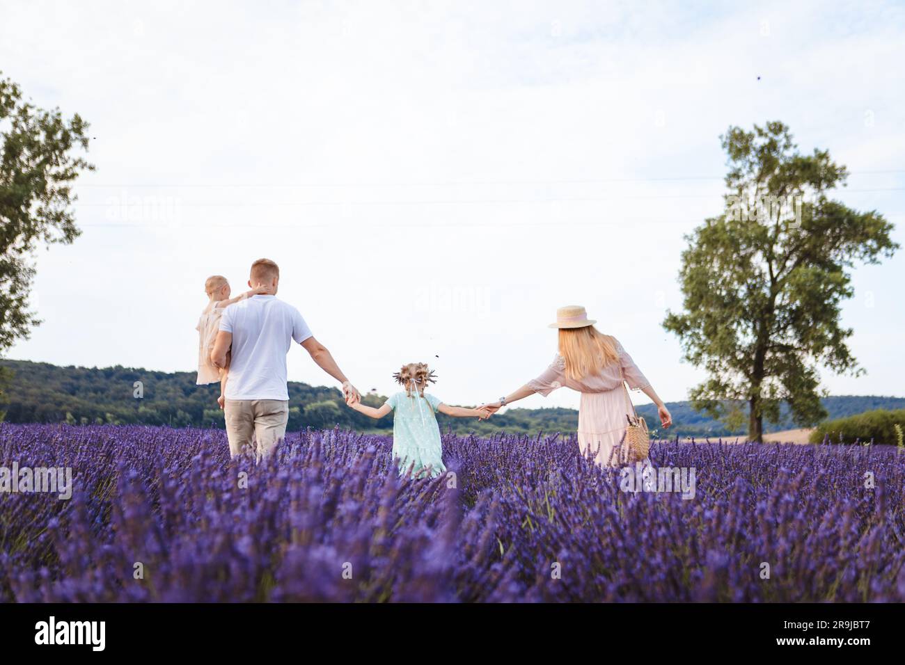 a family walks on a lavender field. father and mother with two daughters Stock Photo