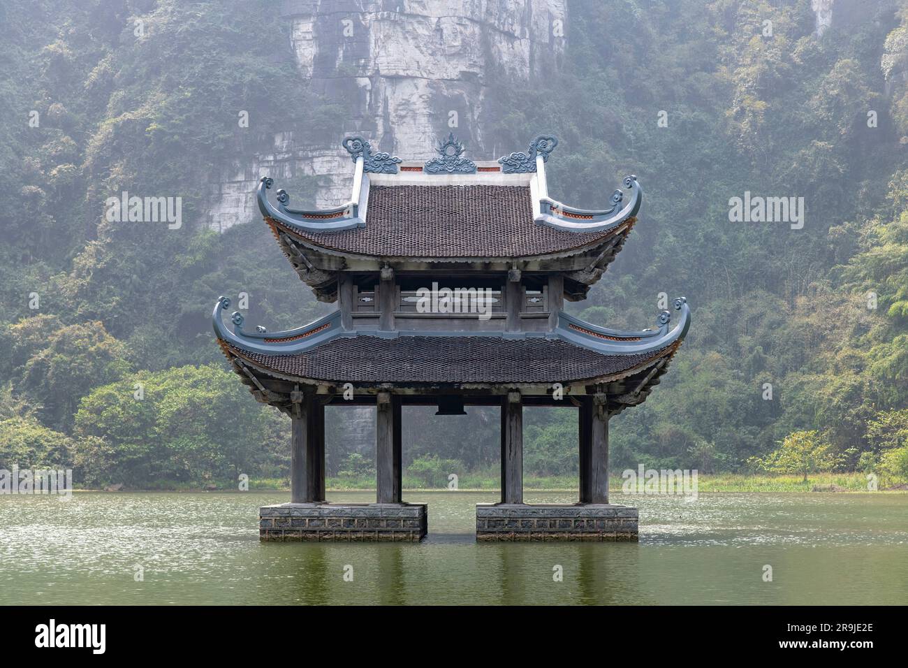 Close up of a temple in the water in front of Vu Lam Palace in Red River Delta of Ninh Bin, Vietnam giving impression it seems to float and is surroun Stock Photo