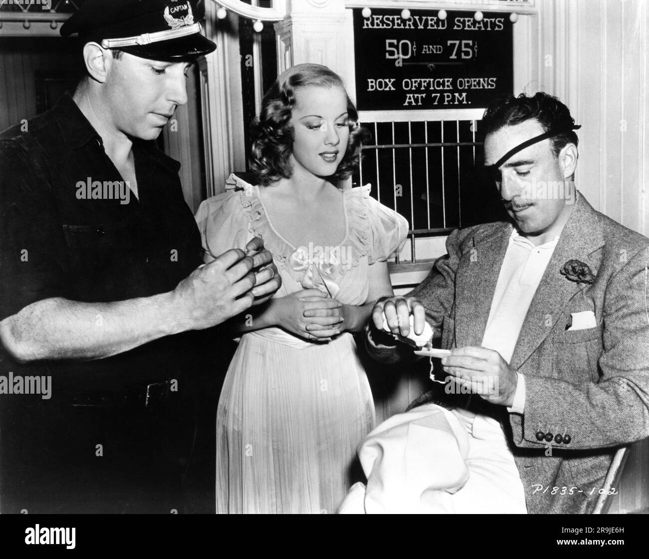 Director RAOUL WALSH (right) teaches LLOYD NOLAN and MARY ''PUNKINS'' PARKER how to roll your own cigarette on set candid during filming of ST. LOUIS BLUES 1939 director RAOUL WALSH Paramount Pictures Stock Photo