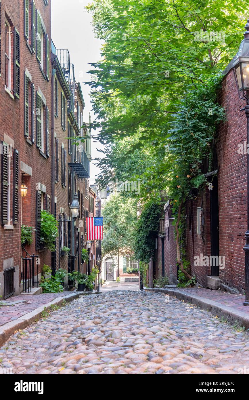 Boston, MA, USA-August 2022; Vertical view down Acorn Street with cobblestones and former coachmen homes in the Beacon Hill neighborhood Stock Photo