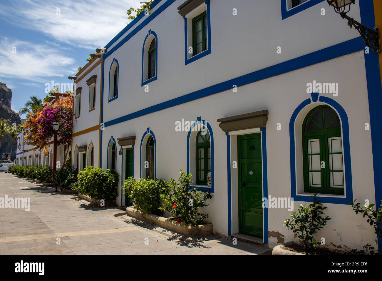 Street of Puerto de Mogán with its white houses with the frames of ...