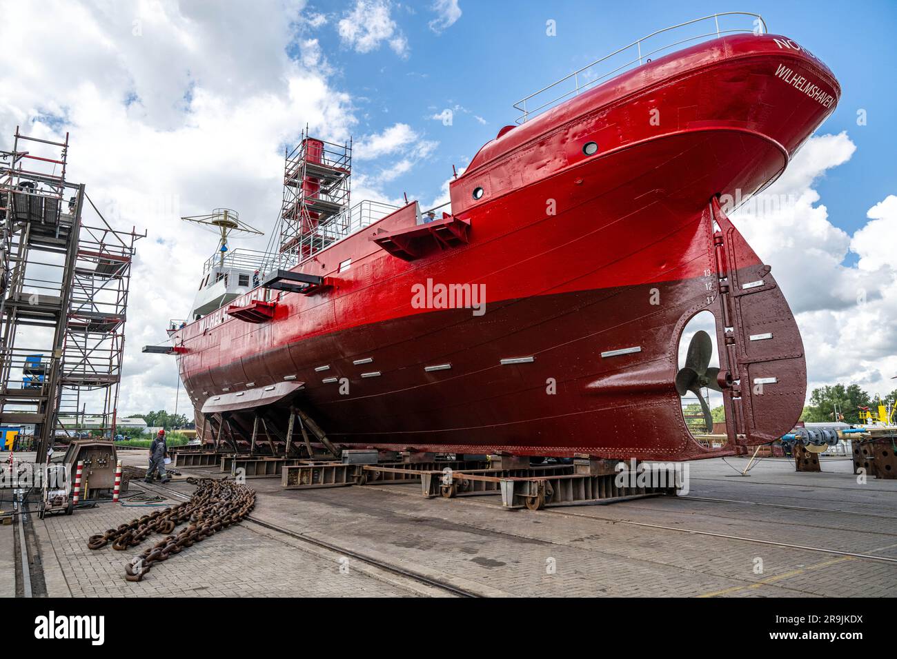 Wilhelmshaven, Germany. 27th June, 2023. The former lightship 'Weser' is pulled out of the shipbuilding hall at Neue Jadewerft. Built in 1907 at Bremer Werft A.G., the ship was initially a reserve lightship for other stations in the North Sea. It was used, for example, at the Norderney and Elbe positions. Now it wears a new signal red paint job and the lettering 'Wilhelmshaven'. Credit: Sina Schuldt/dpa/Alamy Live News Stock Photo