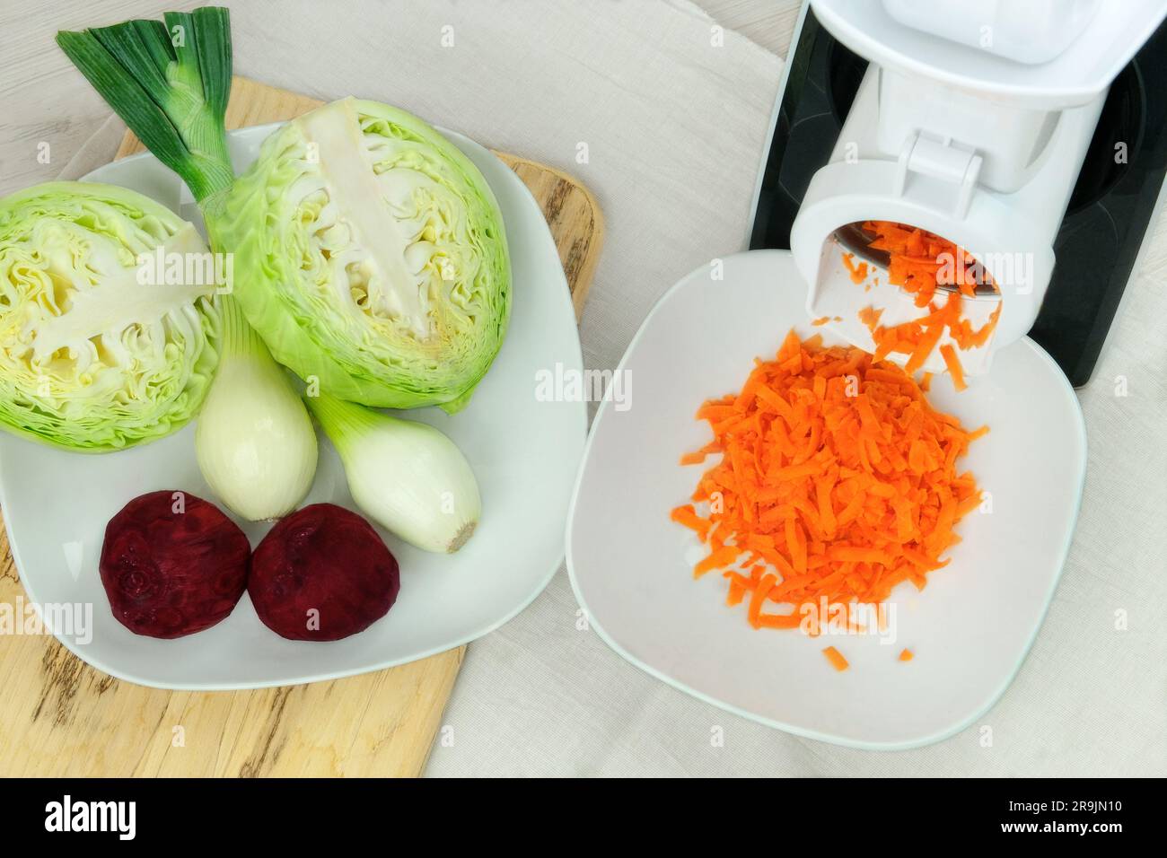 https://c8.alamy.com/comp/2R9JN10/carrots-in-a-vegetable-cutter-on-kitchen-table-chopped-carrots-is-falling-into-a-bowl-homemade-healthy-food-2R9JN10.jpg