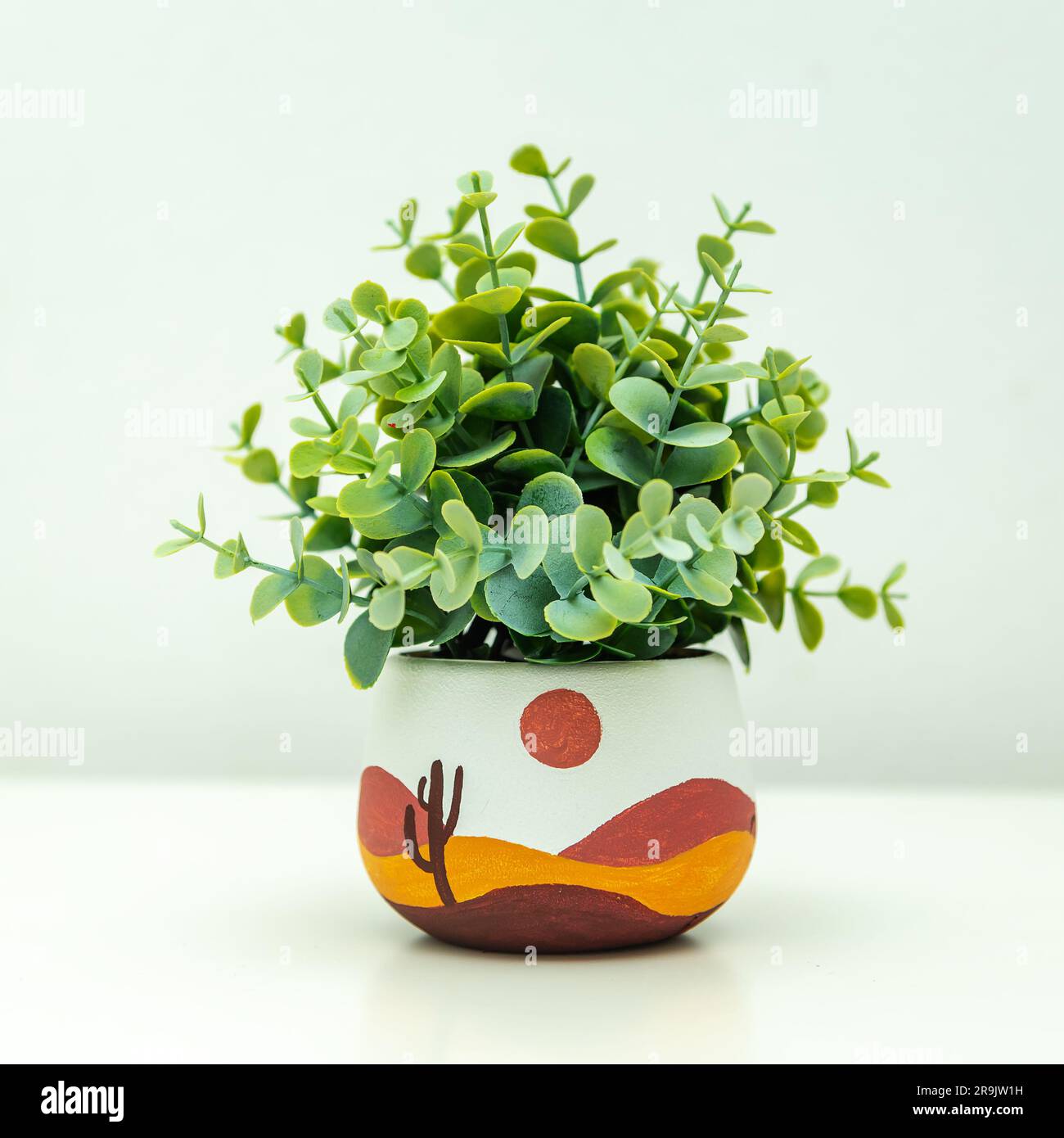 Artificial plant in a clay terracotta pot. Hand painted with acrylics