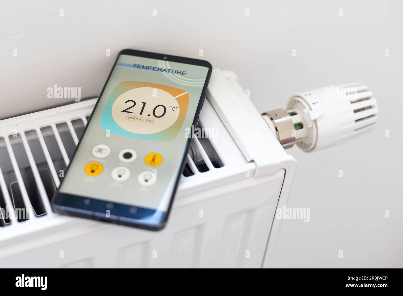Smart Home: Man Controlling Heating Using App Stock Photo