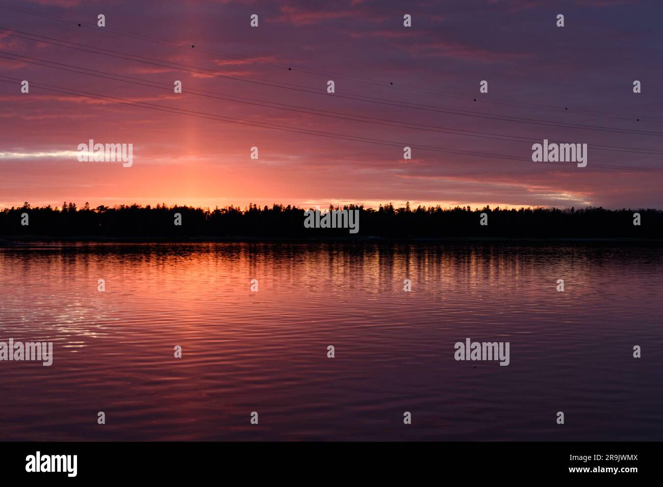 The coastline of islands near Helsinki, at sunset, a red glow in the sky. Stock Photo