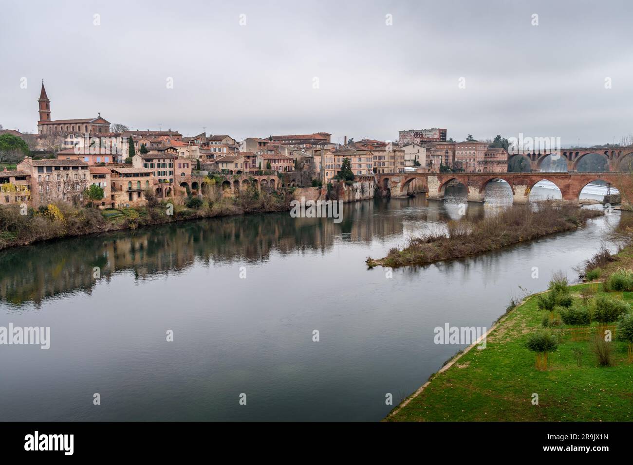 View of Albi, the city and historic buildings from the River Tarn, the Pont Vieux and an island in the stream. Stock Photo