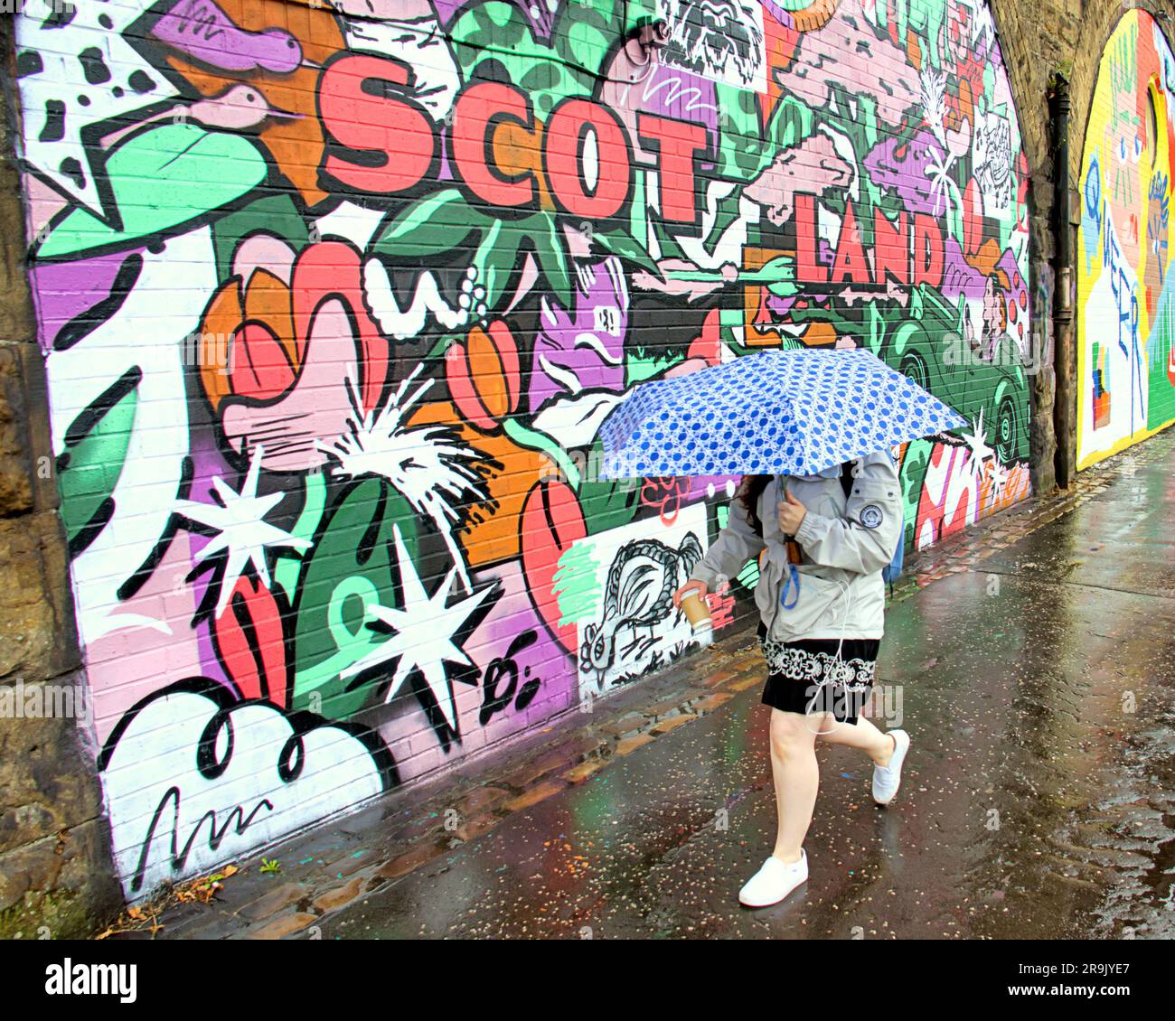 Glasgow, Scotland, UK 27th June, 2023. UK Weather:  Wet in the city as tourists and locals suffer in the rain. The yardwoeks murals on the public path beside the clydeside expressway sum up the countrys climate. Credit Gerard Ferry/Alamy Live News Stock Photo