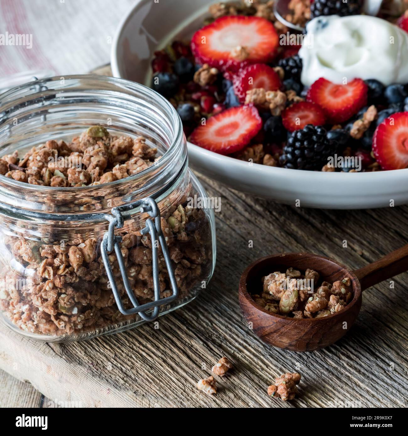 Healthy protein granola clusters with a nutrient dense breakfast bowl in behind Stock Photo Alamy