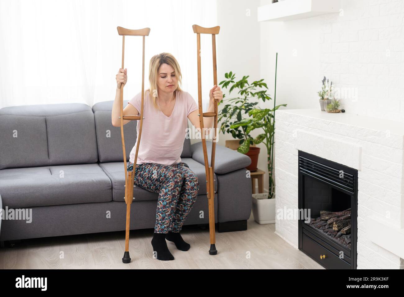 Woman With Leg Injury Using Crutches At Home Stock Photo Alamy