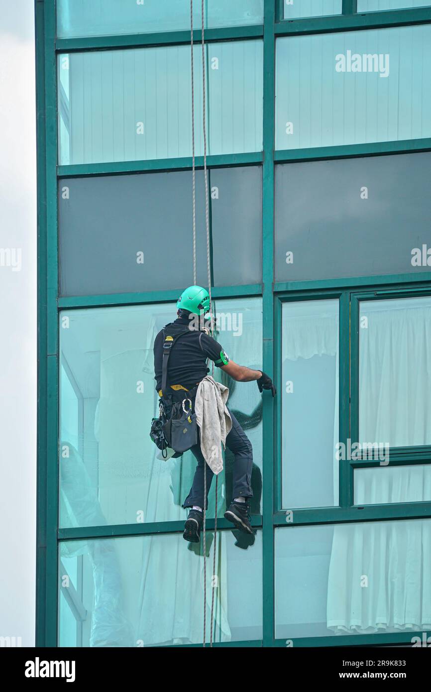 Industrial window cleaner man hanging on roofs with safety equipment