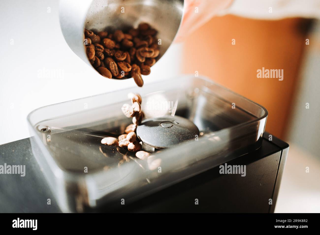 Unrecognizable young man preparing coffee in. Close up of coffee beans. Stock Photo