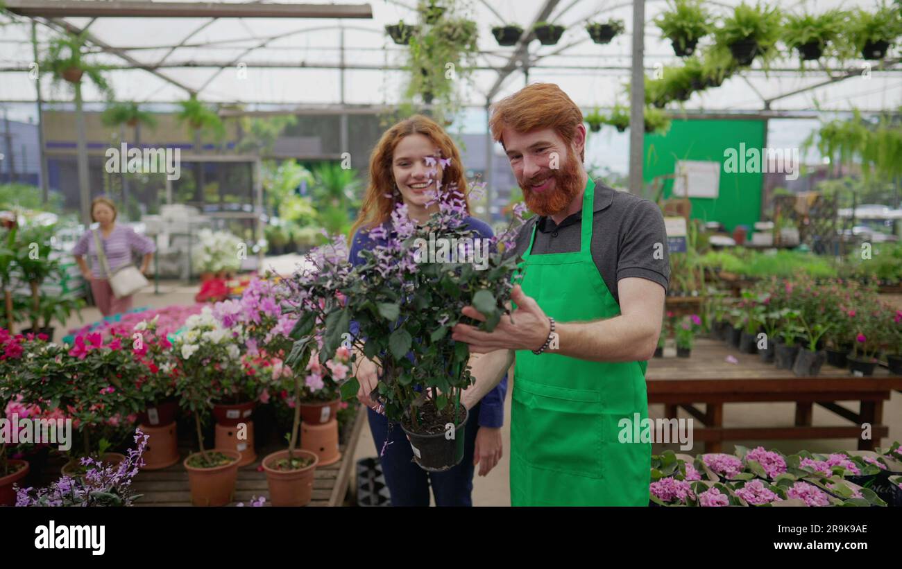 Man helping customer to select plant at Local Business Flower Shop. A