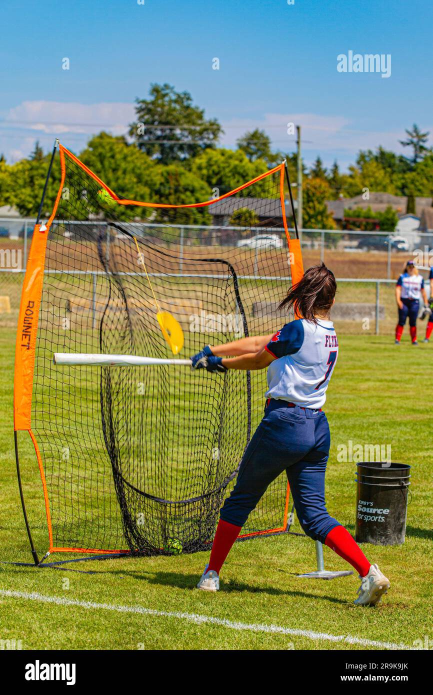 Batting practice before a girls Fastball game on Vancouver Island Canada Stock Photo