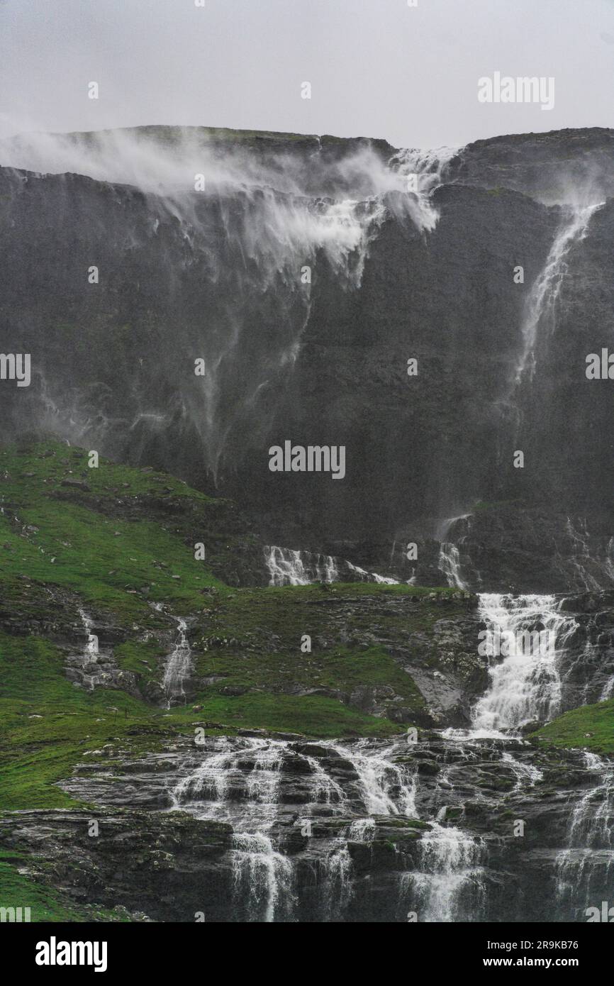 Waterfall jumping down majestic mountain ridge, Saksun, Streymoy Island ...