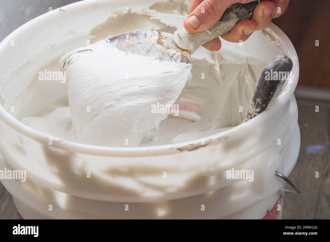 Working with sparkle wall compound spatula human hand construction interior renovation Stock Photo