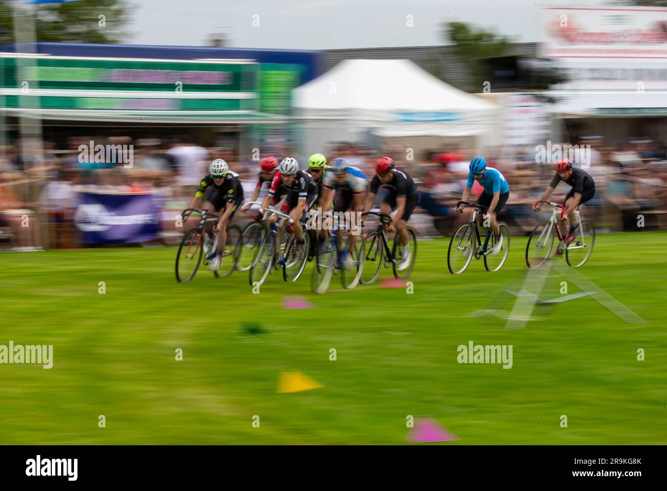 Motion blur as Elite cyclists compete in the bicycle circuit race at the annual Halkirk Highland games in Caithness, Scotland Stock Photo