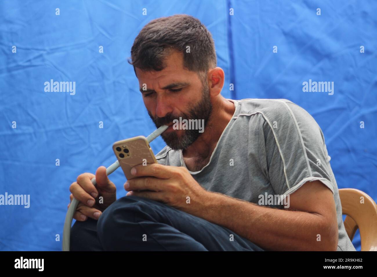 Man spending time on internet watching video in social media and hookah smoking. Leisure time concept idea. Stock Photo