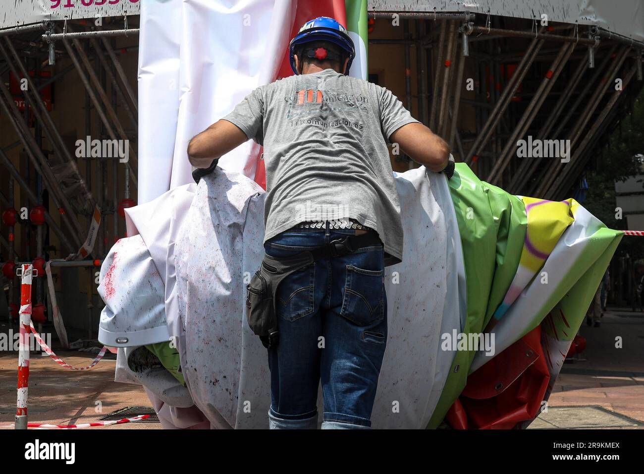 An operator picks up the advertising canvas once it was lowered from the scaffolding. The far-right Spanish party VOX is forced by the Electoral Board of the zone to remove the 'tarpa of hate' installed in a building in Madrid. It has been considered that the slogan 'Decide what matters', present on the banner next to the image of the trash can in which the LGTBIQ+ flag, the feminist or the 2030 agenda are thrown, can be considered electoral propaganda and, therefore, would infringe the Organic Law of the General Electoral Regime. Stock Photo