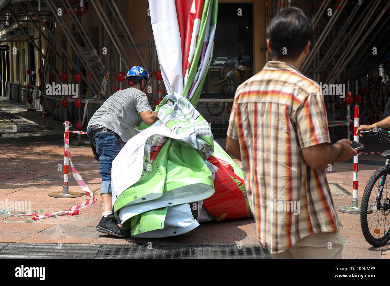 An operator picks up the advertising canvas once it was lowered from the scaffolding. The far-right Spanish party VOX is forced by the Electoral Board of the zone to remove the 'tarpa of hate' installed in a building in Madrid. It has been considered that the slogan 'Decide what matters', present on the banner next to the image of the trash can in which the LGTBIQ+ flag, the feminist or the 2030 agenda are thrown, can be considered electoral propaganda and, therefore, would infringe the Organic Law of the General Electoral Regime. Stock Photo