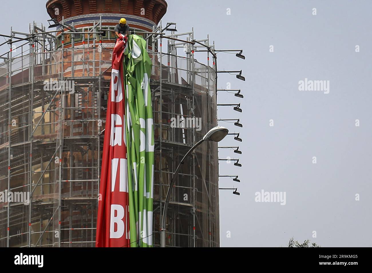 An operator works on the scaffolding to take down the advertising canvas. The far-right Spanish party VOX is forced by the Electoral Board of the zone to remove the 'tarpa of hate' installed in a building in Madrid. It has been considered that the slogan 'Decide what matters', present on the banner next to the image of the trash can in which the LGTBIQ+ flag, the feminist or the 2030 agenda are thrown, can be considered electoral propaganda and, therefore, would infringe the Organic Law of the General Electoral Regime. Stock Photo