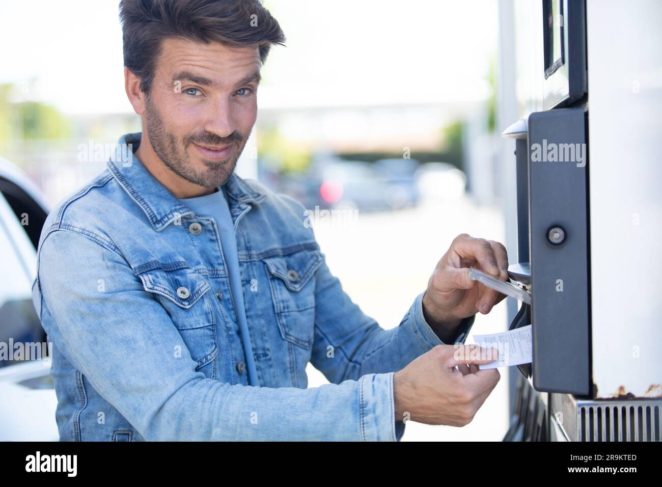 young man paying for car parking at machine Stock Photo - Alamy