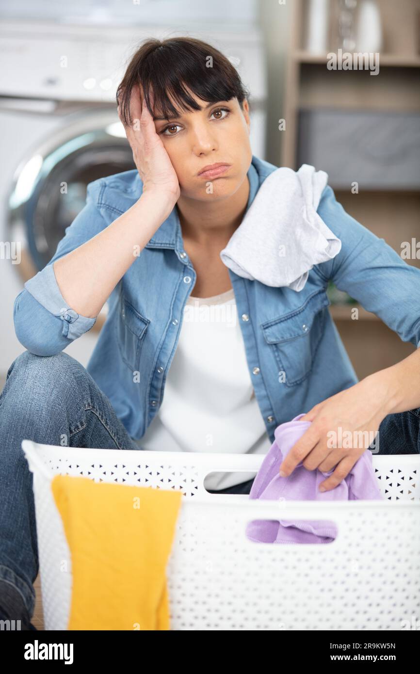 frustrated and overwhelmed girl is fed up with doing laundry Stock