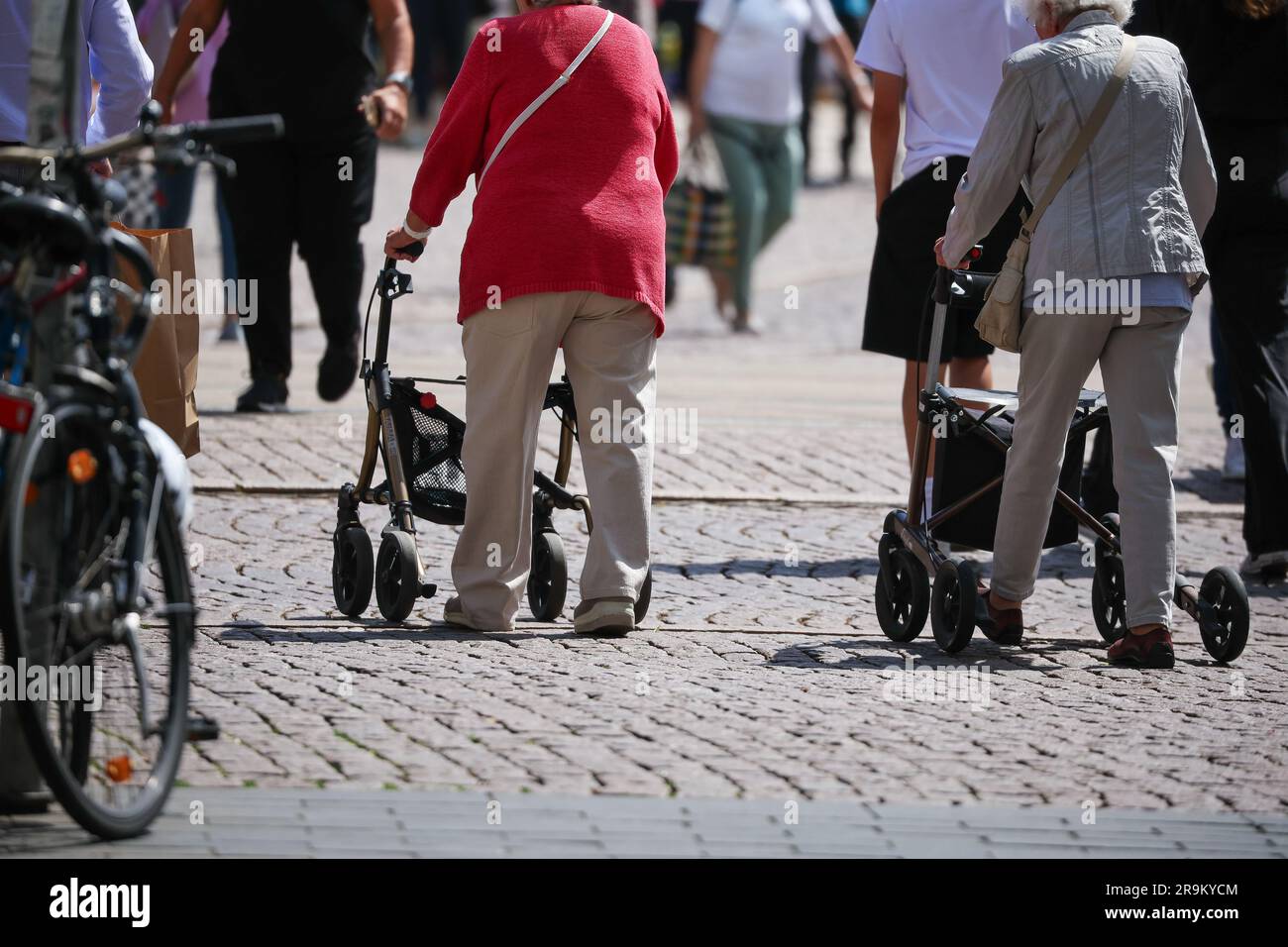 Leipzig, Germany. 27th June, 2023. Senior citizens walk through Leipzig's city center with their walkers. The approximately 21 million pensioners in the country will receive more money starting in July. With the annual pension adjustment, old-age pensions will rise by 4.39 percent in the west and 5.86 percent in the east. In addition, almost 30 years after reunification, the so-called pension value in the east will be brought into line with that in the west - one year earlier than planned. Credit: Jan Woitas/dpa/Alamy Live News Stock Photo