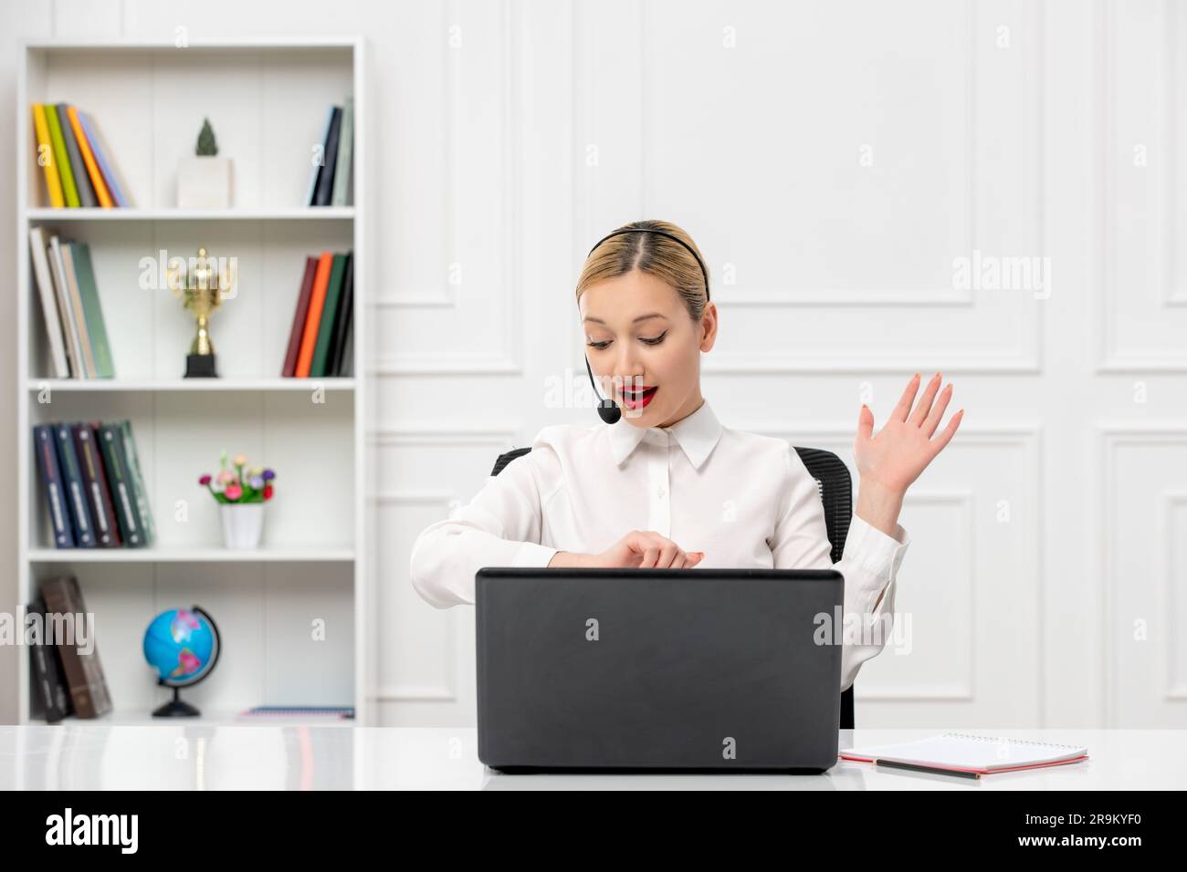 customer service cute blonde girl in office shirt with headset and computer looking at clocks Stock Photo