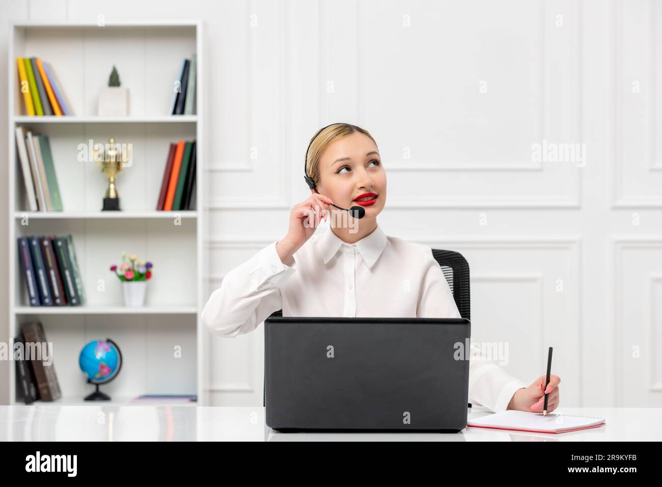 customer service cute blonde girl in office shirt with headset and computer looking up and thinkin Stock Photo