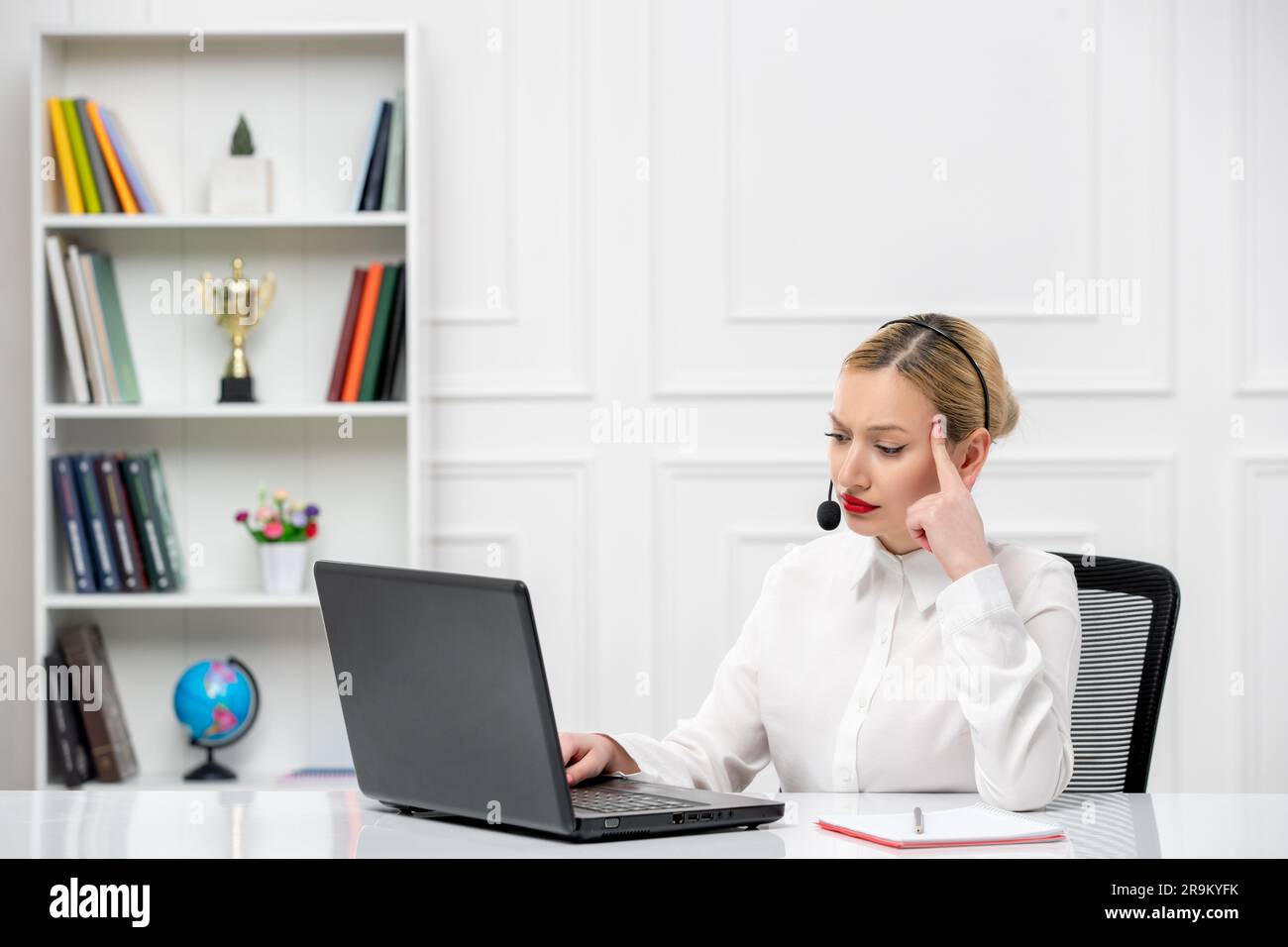 customer service cute blonde girl office shirt with headset and computer confused touching temples Stock Photo