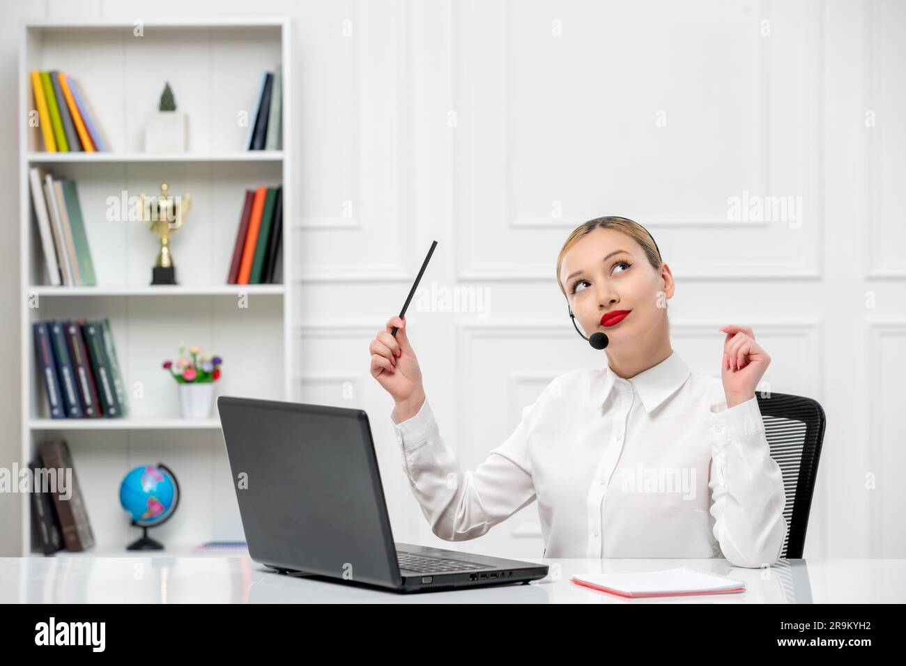 customer service cute blonde girl office shirt with headset and computer looking up Stock Photo