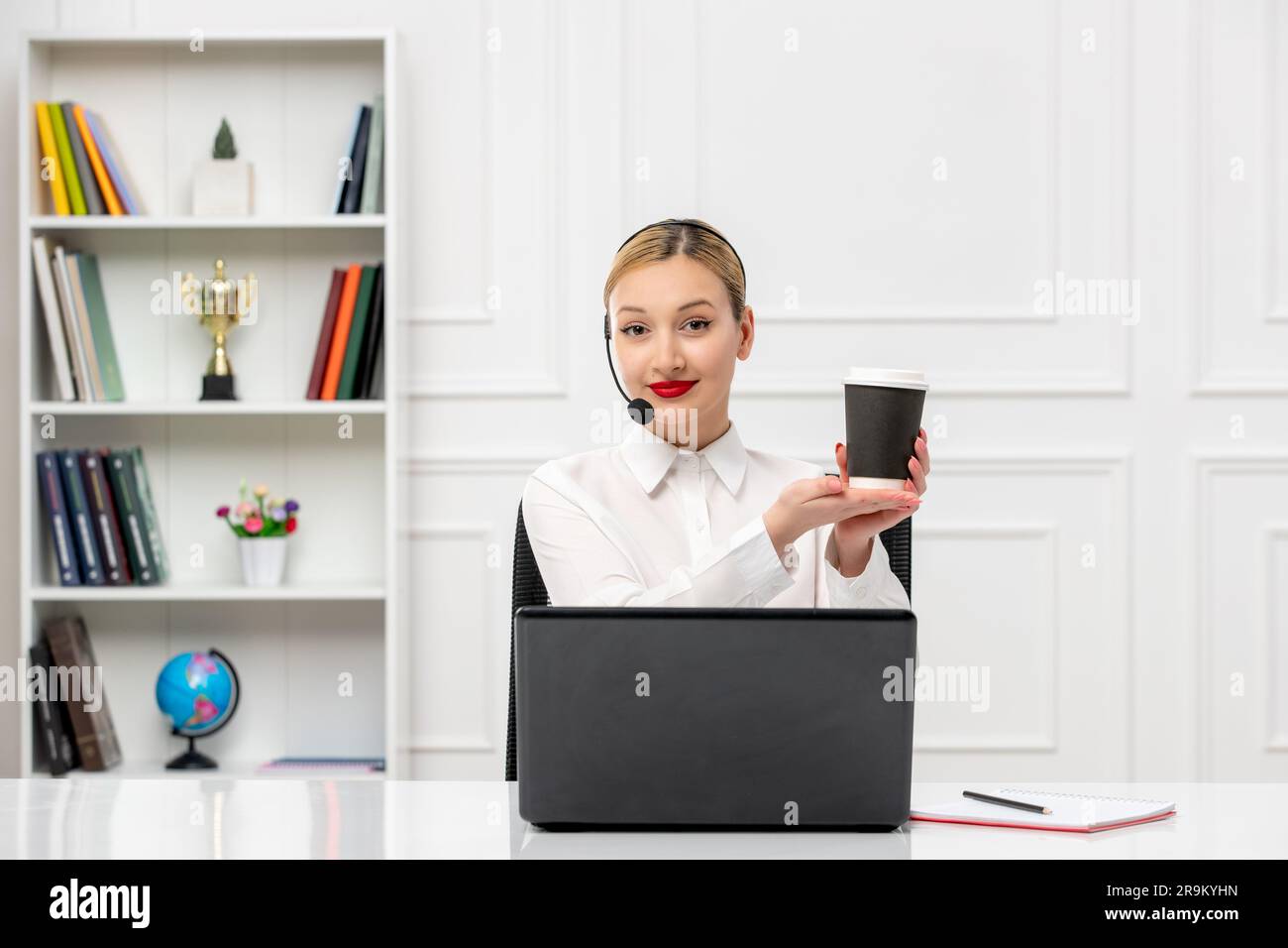 customer service cute blonde girl office shirt with headset and computer holding a coffee cup Stock Photo