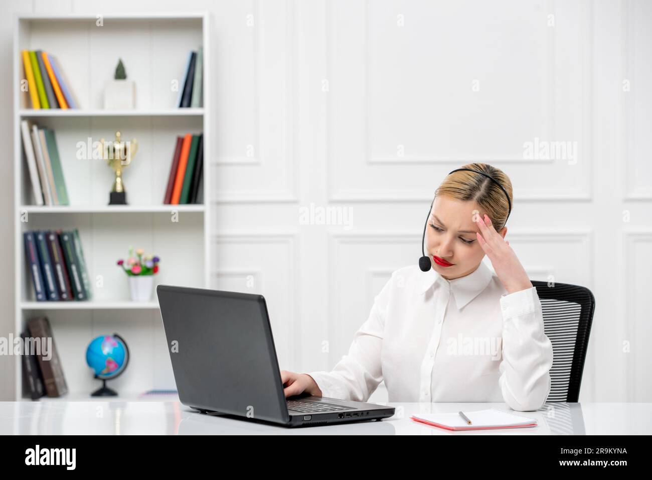 customer service cute blonde girl office shirt with headset and computer touching head tired Stock Photo
