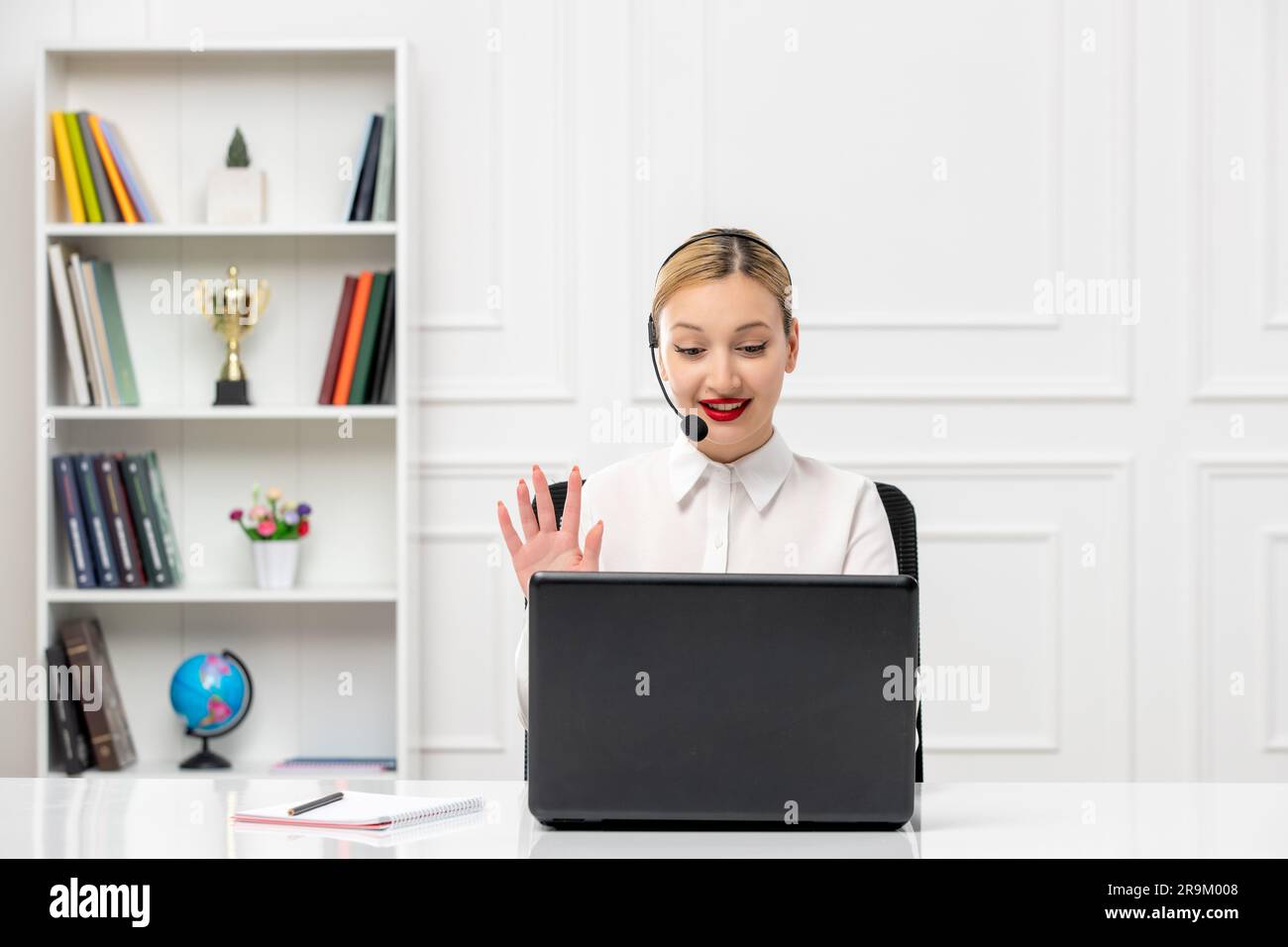 customer service cute woman in white shirt with headset and computer saying hello Stock Photo