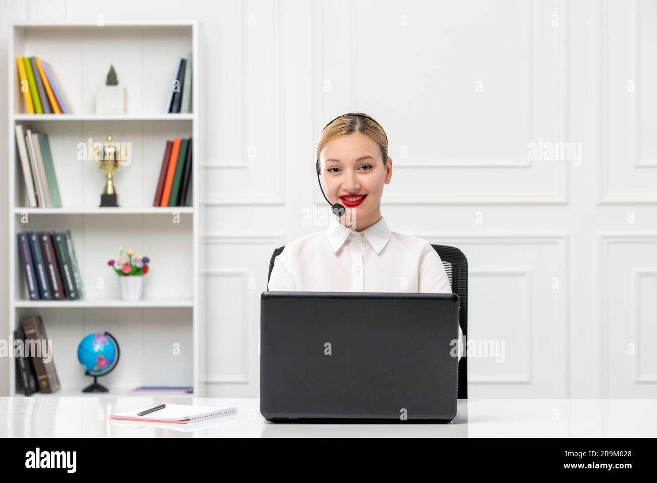 customer service cute woman in white shirt with headset and computer smiling with red lipstick Stock Photo