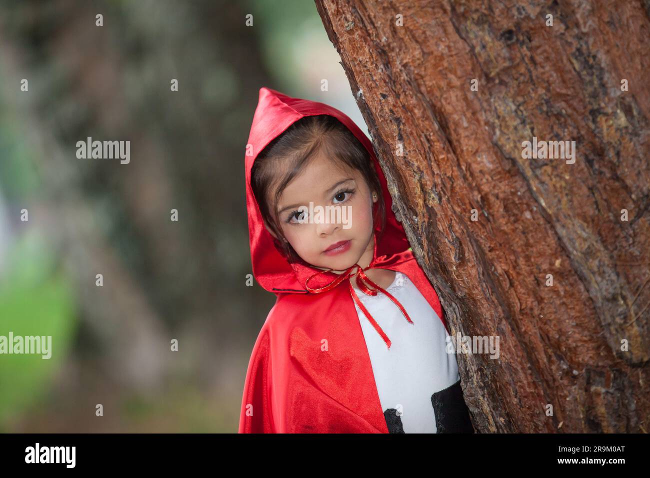 Sweet girl wearing a Little red riding hood costume. Real family having