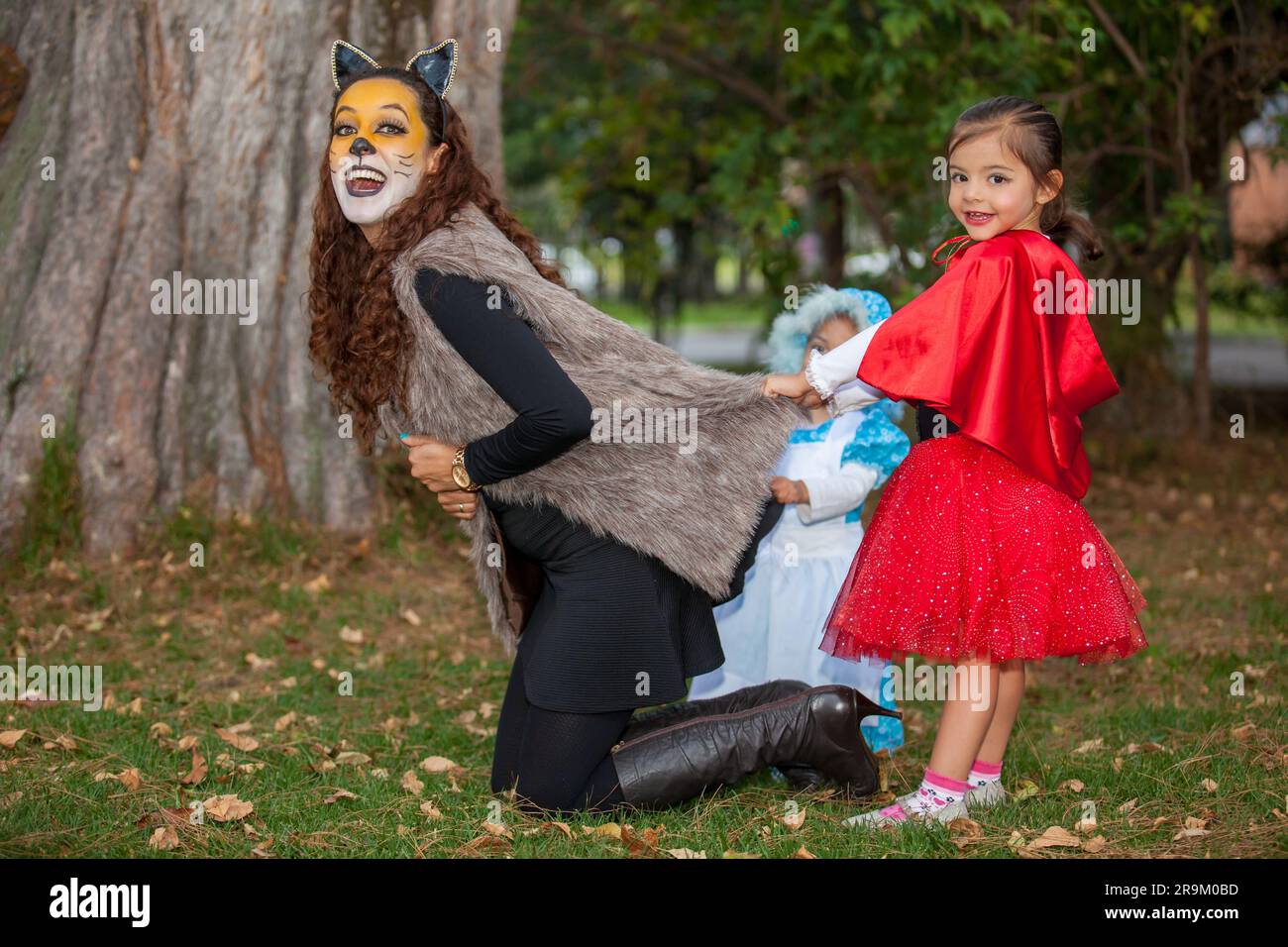 Beautiful young mother on wolf costume playing with her daughters. Real