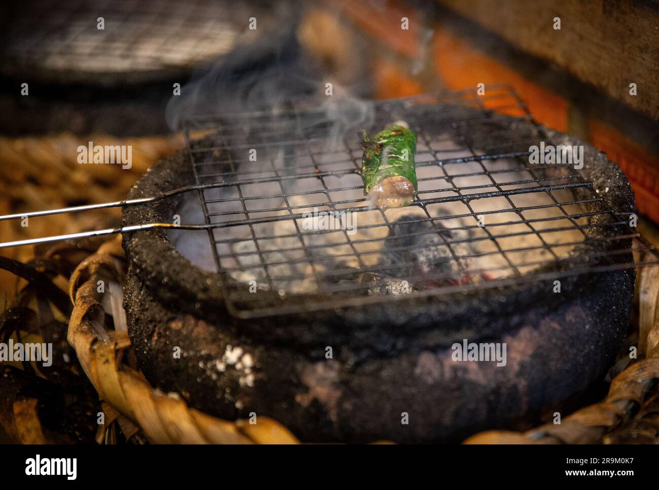 Grilling seafood in Asia over coals for an appetizer Stock Photo