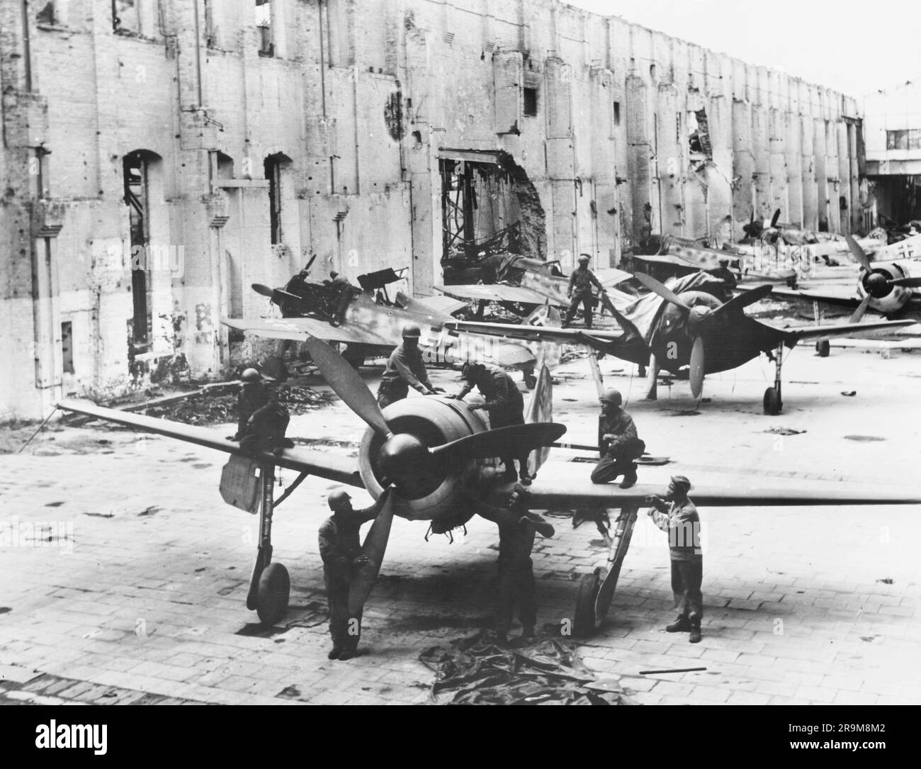 U.S. Army Quartermaster troops inspecting found Focke-Wulf fighter planes grounded either by rubble or lack of gasoline, Oschersleben, Germany, Sgt. J. Pazen, Carl Spaatz Collection, April 1945 Stock Photo