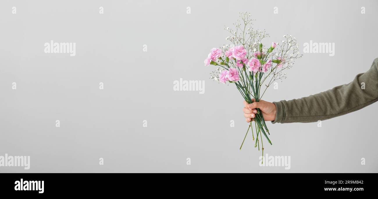 Hand holding beautiful bouquet on light background. Banner for design