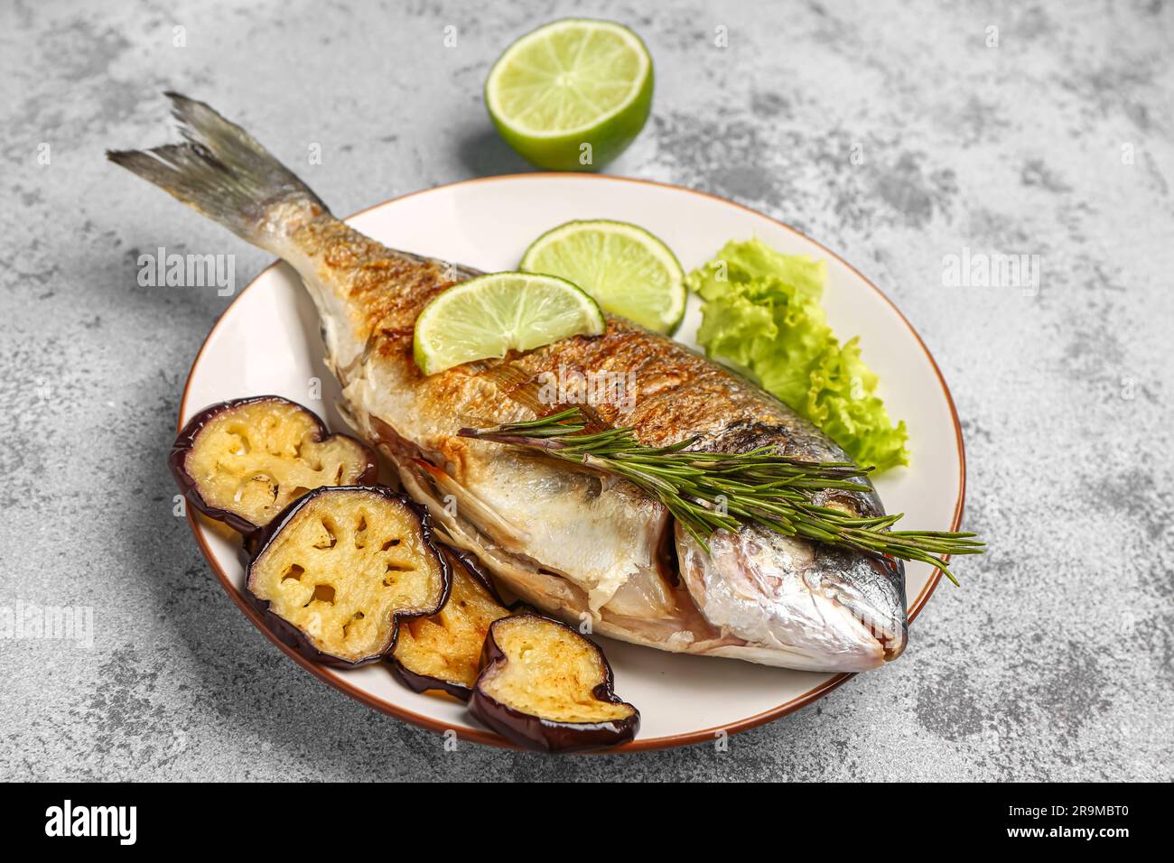 plate-with-tasty-grilled-dorado-fish-on-light-background-stock-photo